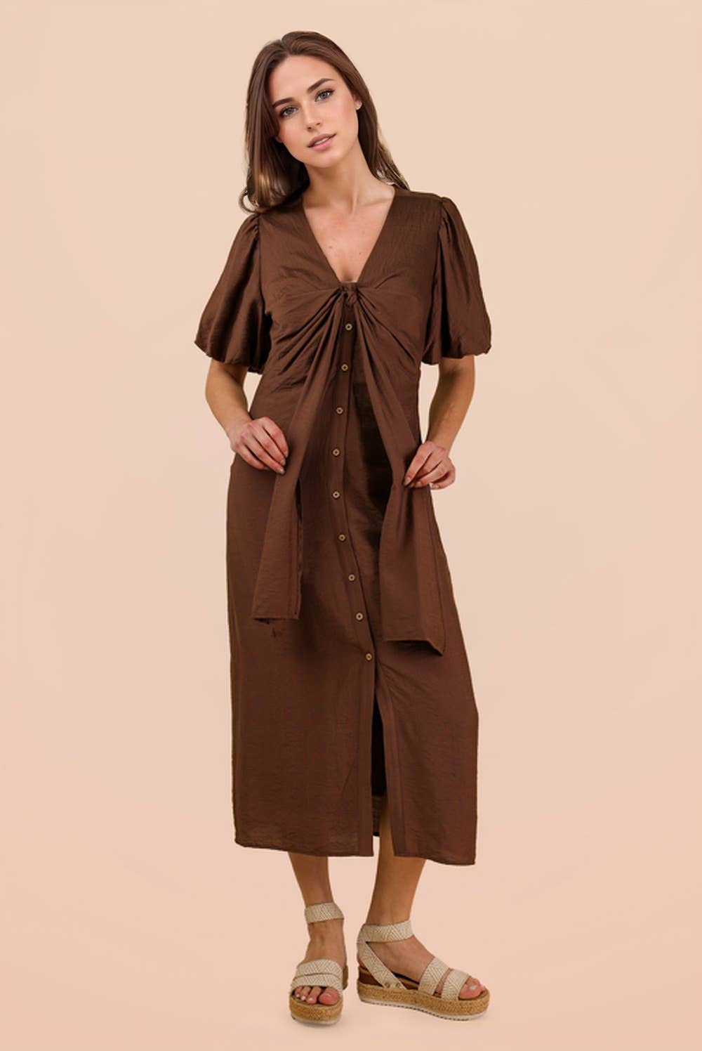 A woman wears a brown VERY J Mocha Front Tie Midi Dress with short puff sleeves, a button-front closure, and a waist tie.