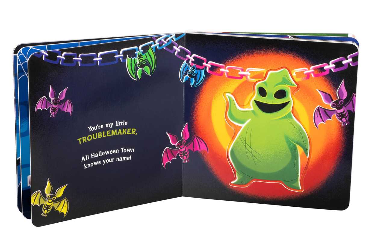 An open copy of You’re My Little Nightmare by Grace Baranowski from Simon & Schuster displays a green ghostly figure smiling amidst colorful bats and chains, accompanied by the text “You’re my little TROUBLEMAKER, All Halloween Town knows your name!” on the left page.